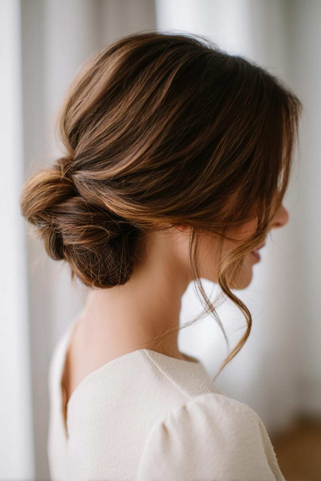15+ Stunning Ways to Style Dark Brown Hair (From Sleek to Voluminous). - 11. Low Bun with Face-Framing Pieces