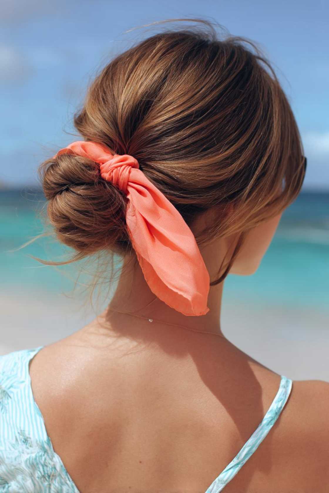 Accessorize Your Shoreline Style: 18+ Beach Hairstyles with Scarves, Hats & Clips - 19. Effortless Low Bun with Ribbon