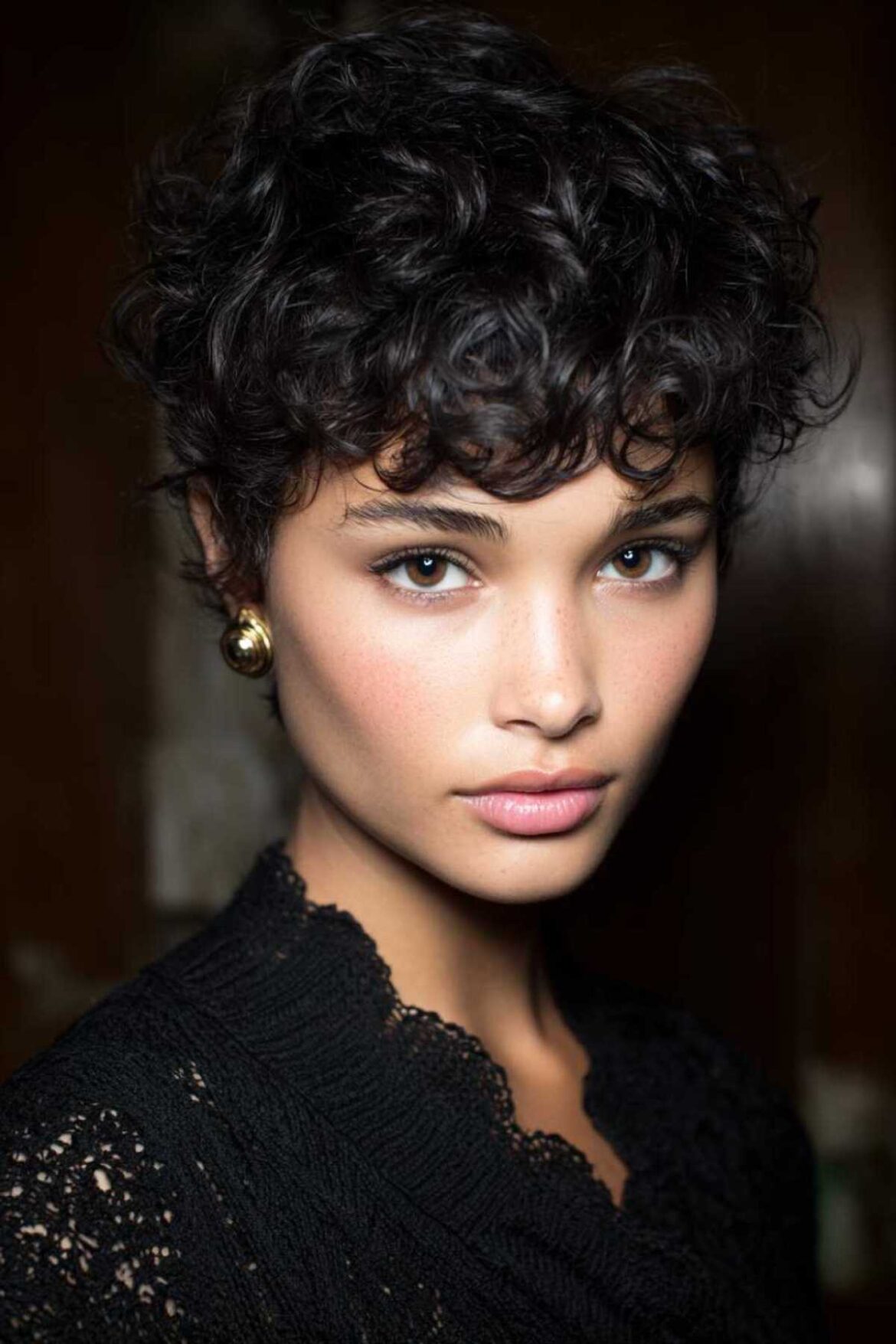 A close-up of a thick pixie cut with feathered layers, highlighting the feathered texture and face-framing details.